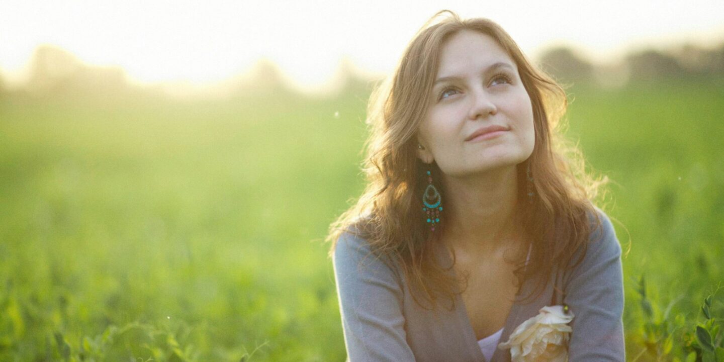 a woman sitting in a field of green grass