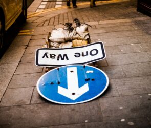 a blue and white street sign sitting on the side of a road