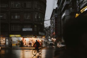 A man riding a bike down a street next to tall buildings