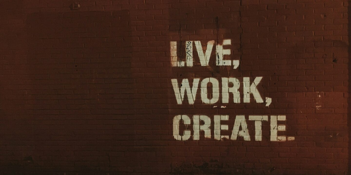 red brick wall with live, work, create. quote